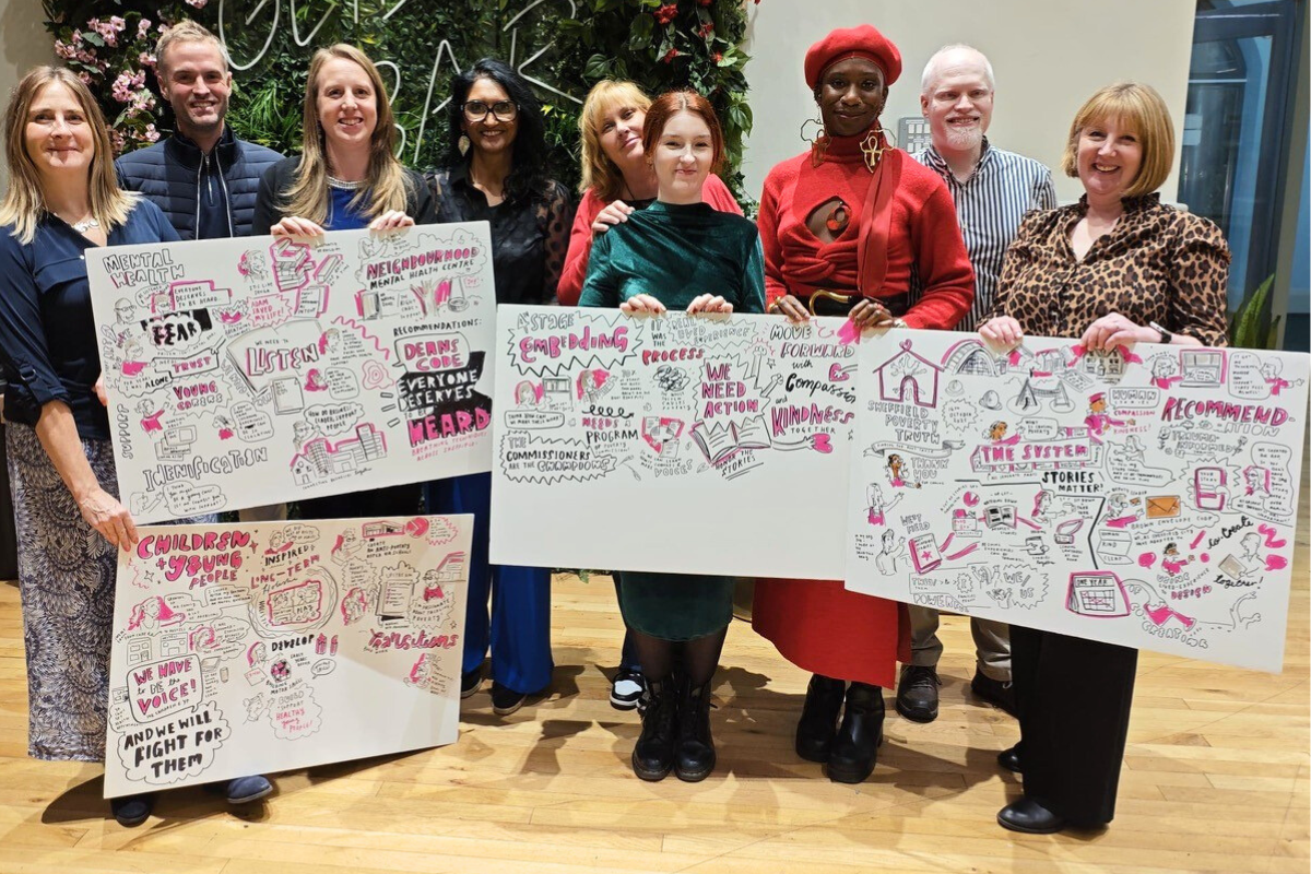 Commissioners gather with signs for the closing event of Sheffield Poverty Truth Commission.
